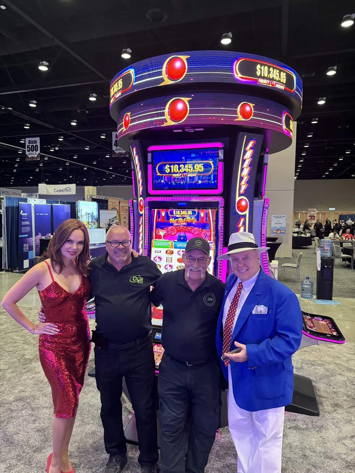 Karl Suggs with Mike and friends in front of a slot machine at a gaming event